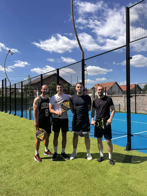 Vuk and three friends on a padel court, on the fake grass, after a match