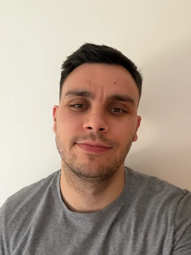 Vuk, in a plain grey t-shirt, looking like someone who has fixed a lot of canonicals